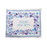 Importez les couleurs d'Israel jusqu'à votre table de Shabbat ou Yom Tov avec cette Couverture pour le Pain du Shabbat aux motifs de l'abondance dans des tons de bleu, mauve et violet sur un fond blanc.